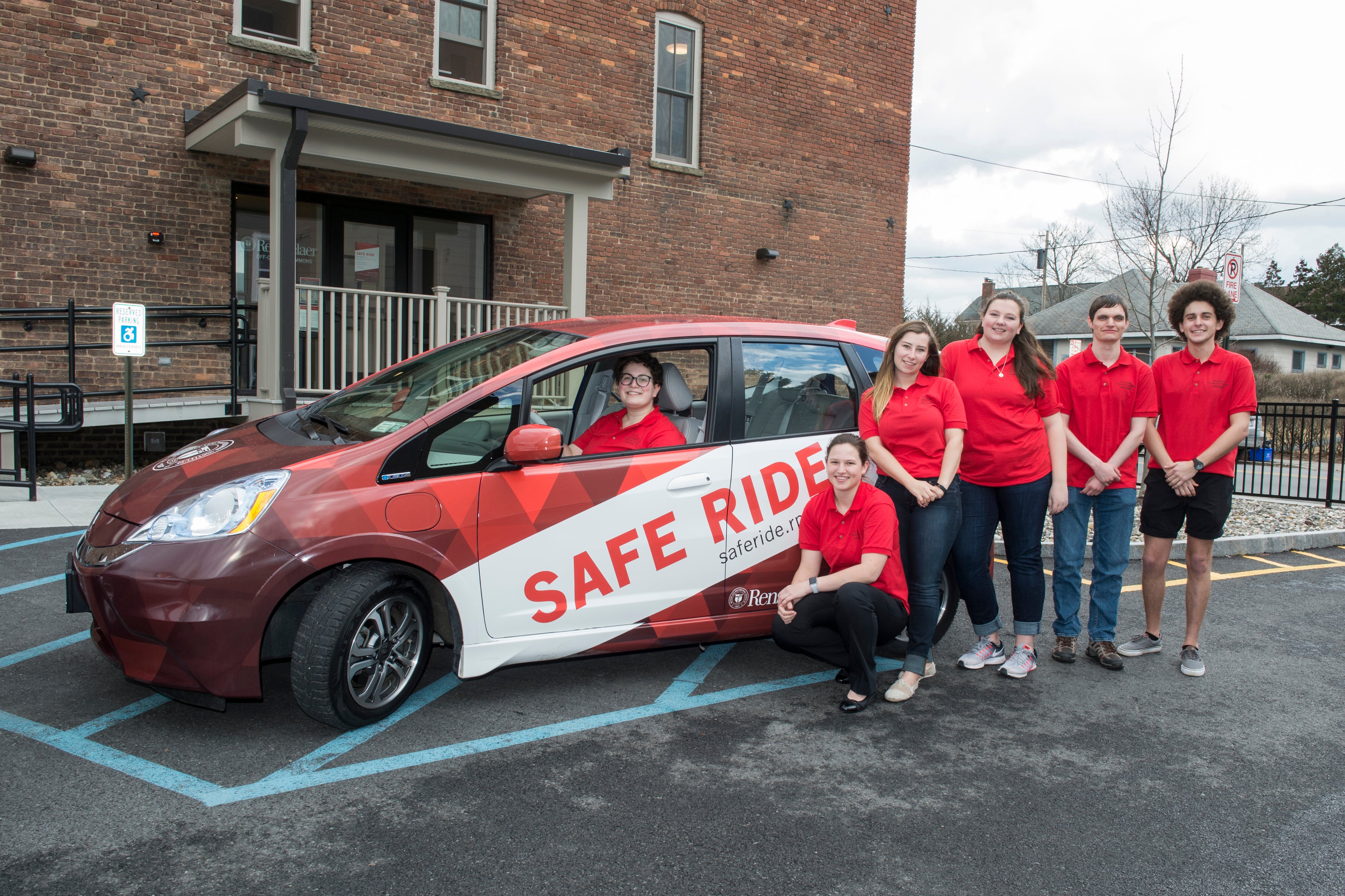 Safe Ride Staff stand outside the new Safe Ride vehicles